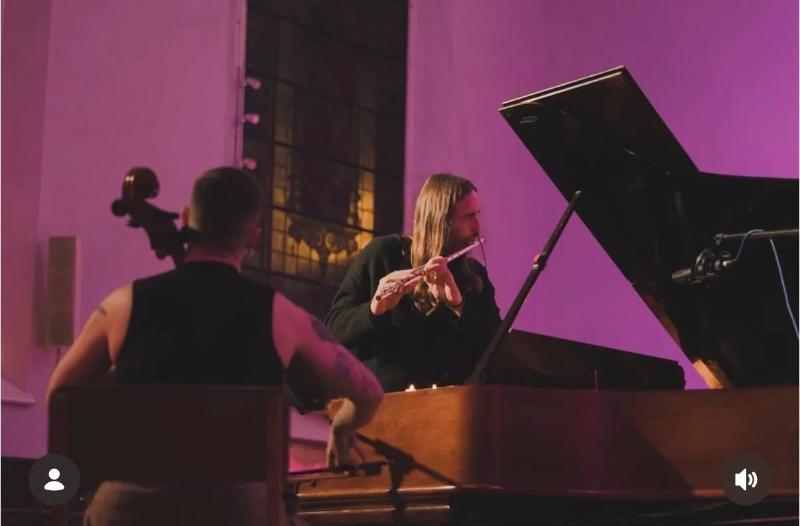 Playing flute beside a grand piano in a church